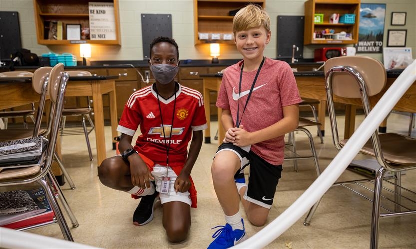 Two students work on a mini rollercoaster track